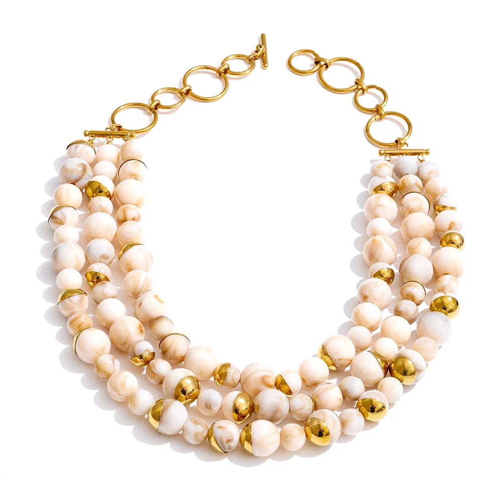 Three-strand layered necklace in ivory marbled beads with gold accents