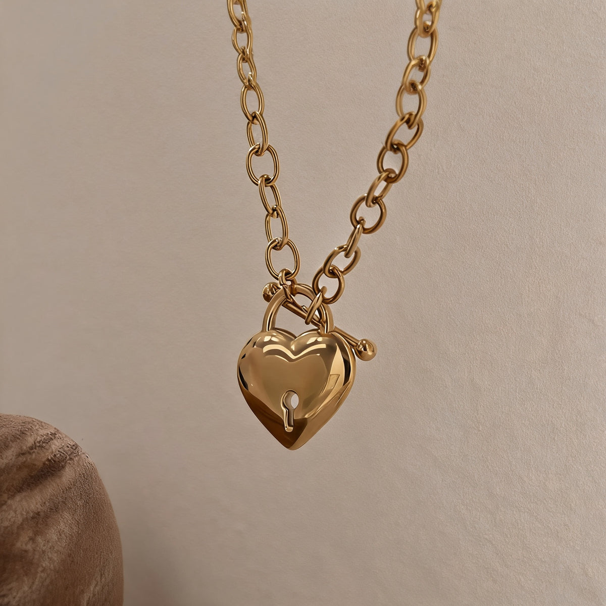 Close-up of the gold puffed heart padlock pendant and T-bar toggle