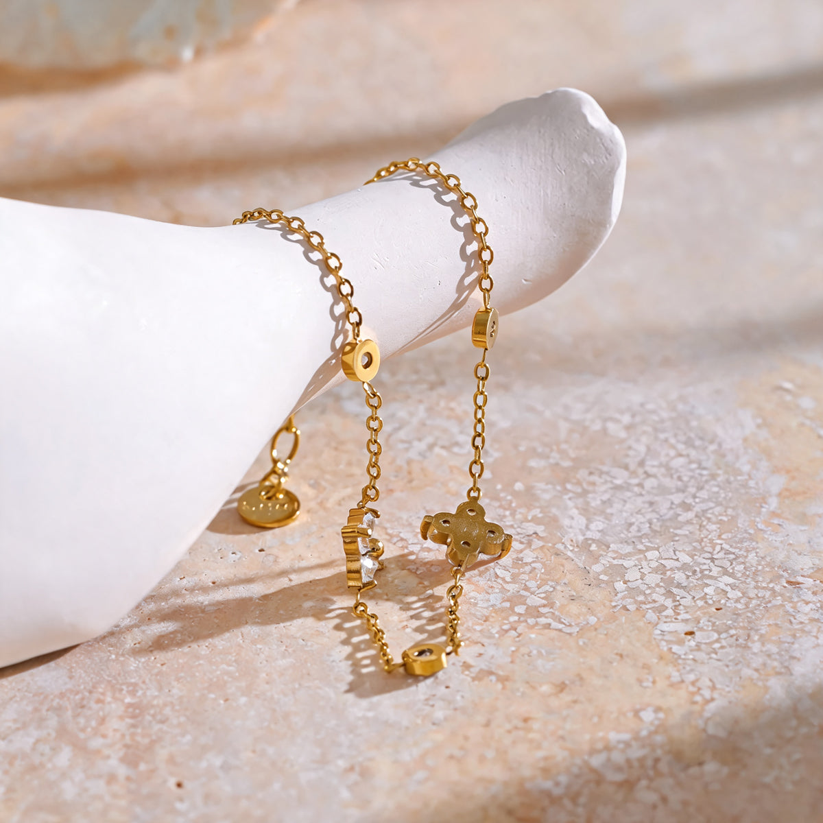Gold Flora zirconia flower bracelet styled on a ceramic form