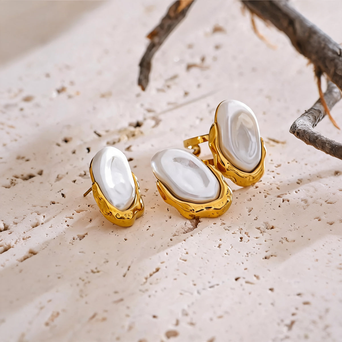 Maren pearl stud earrings and open ring on a travertine ledge