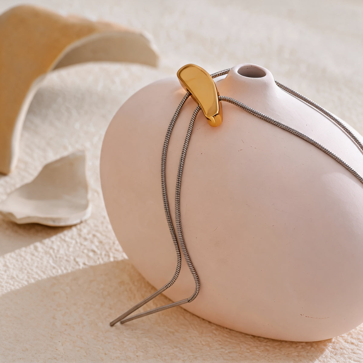 Close-up of the gold-plated bar pendant on the silver-tone snake chain