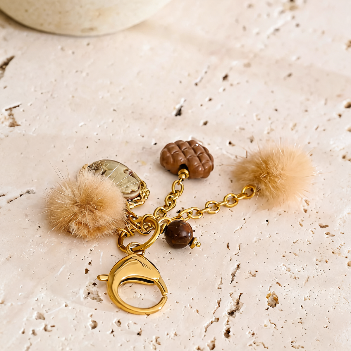 Posy Heart Portrait Keychain in Camel - gold-plated charm keychain with resin cameo, quilted heart and faux fur poms - overhead lay with charms spread