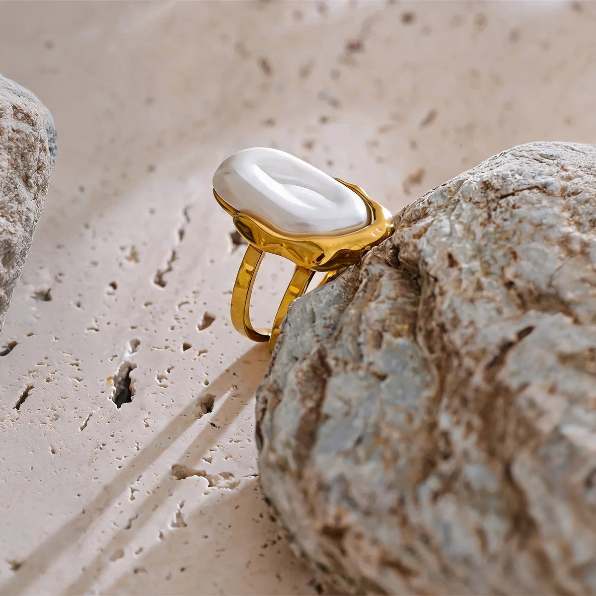Maren open pearl ring resting on a raw stone