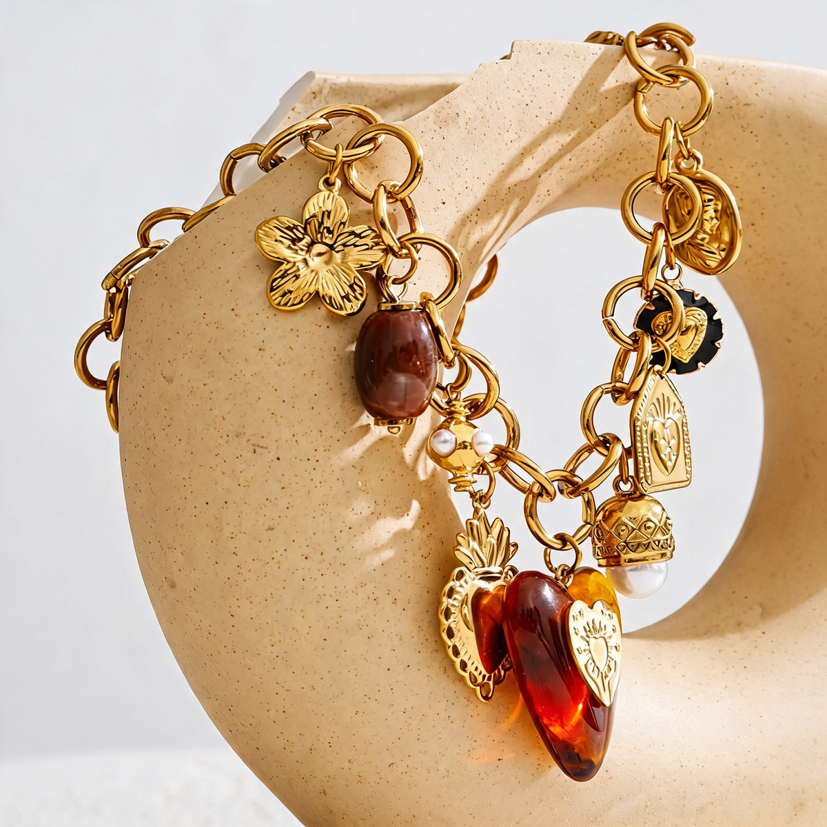 Ramona Long Drop Necklace draped over a sculptural ceramic form