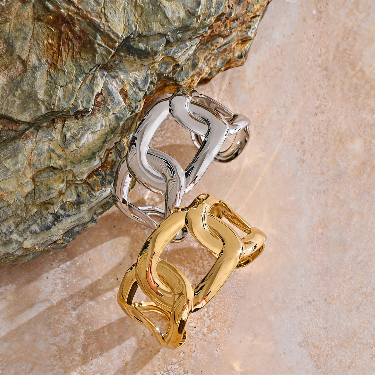 Hazel Chain Bangle in gold and silver on warm travertine