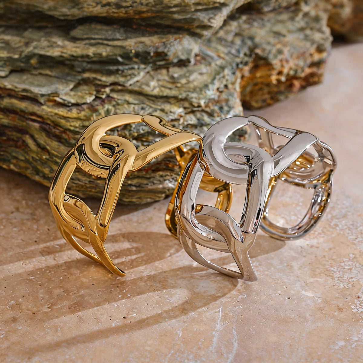 Gold and silver Hazel Chain Bangle beside a stone slab