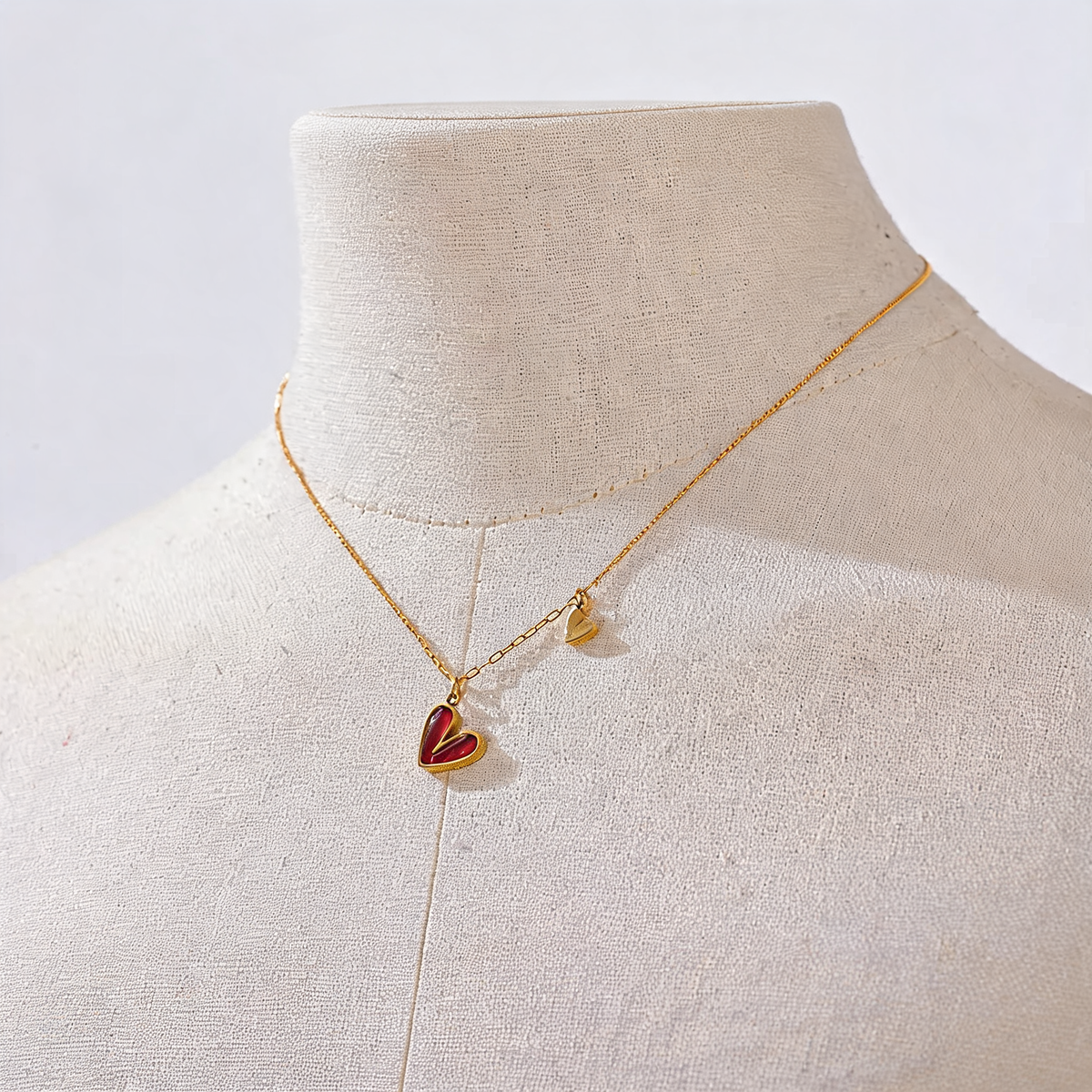Rosa red enamel heart necklace shown on a linen bust