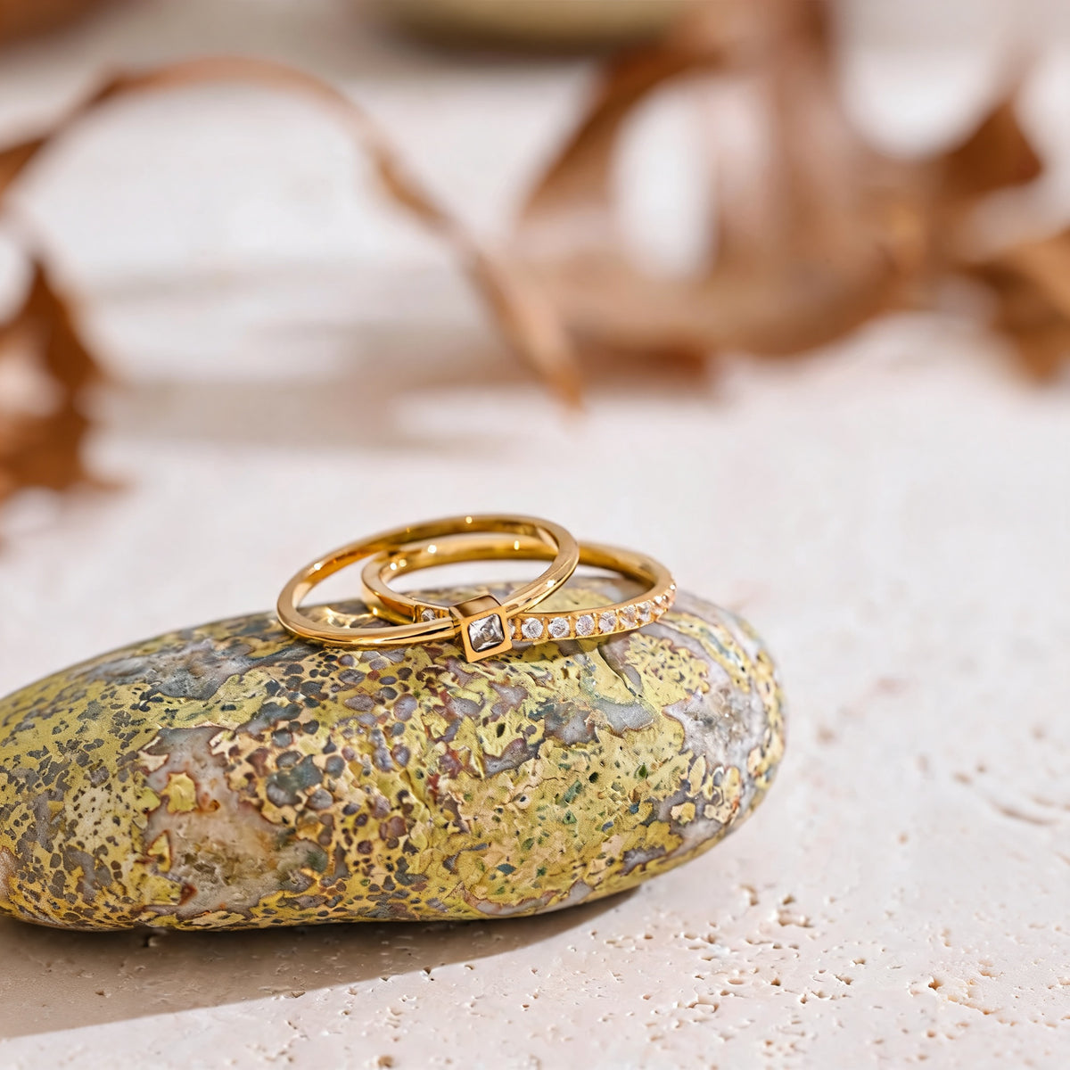 Rosie zirconia ring set resting on a lichen stone