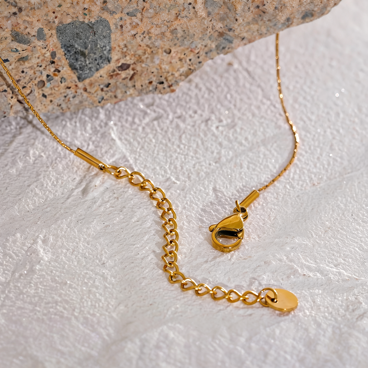 Close view of the gold chain lobster clasp and extender